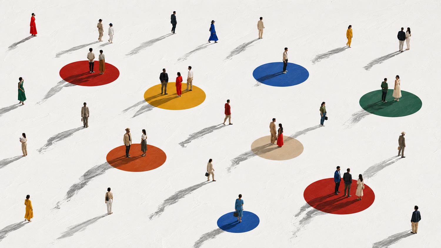 An aerial view of many people on a white field, a few of them standing on coloured circles